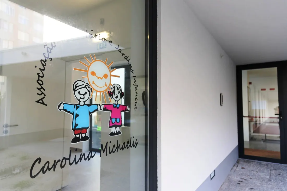 Porta de vidro da entrada com o logótipo das duas crianças e do sol