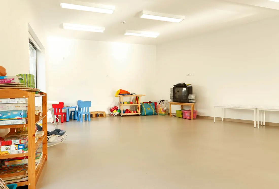 Sala do jardim de infância com estantes e espaço de brincadeira