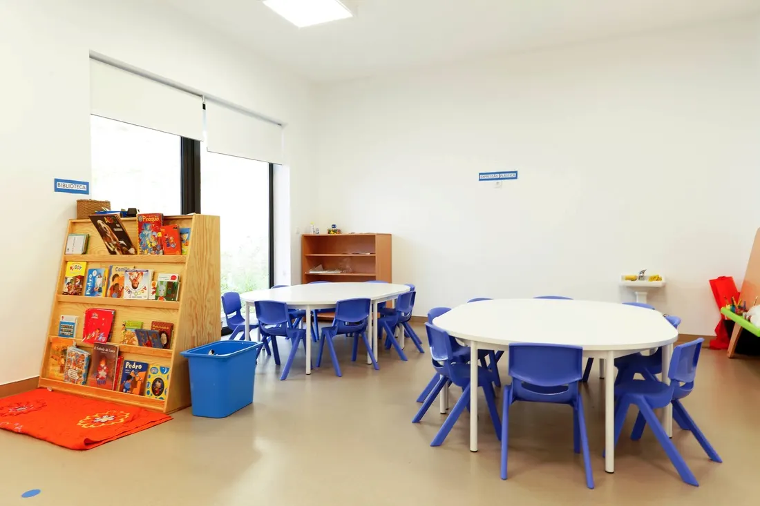 Sala com cantinho dos livros e mesas azuis