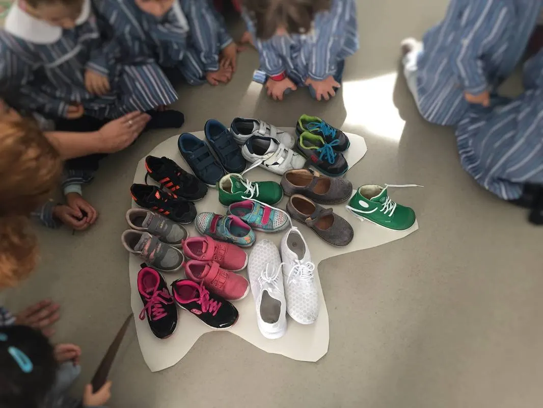 Sapatos das crianças arrumados em roda no chão da sala