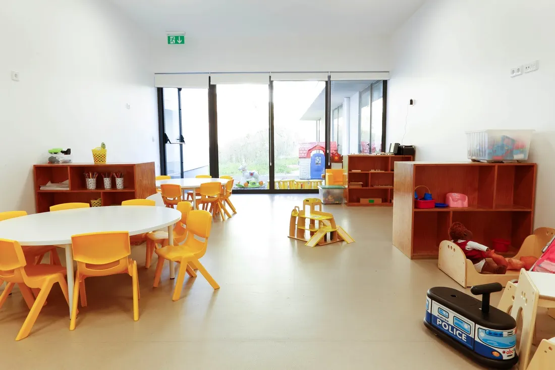 Sala luminosa com mesas redondas e cadeiras amarelas